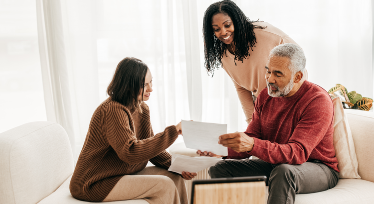 Photo of a real estate agent showing something to a couple