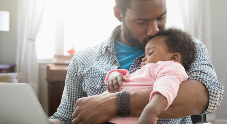 Photo of a father kissing his child on the head