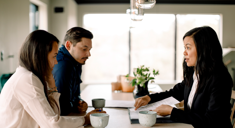 Real estate agent sitting at table with a couple