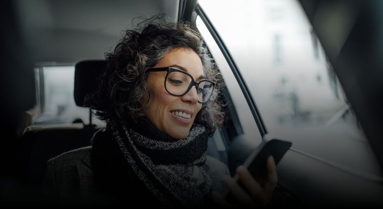 Woman in a car looking at her phone
