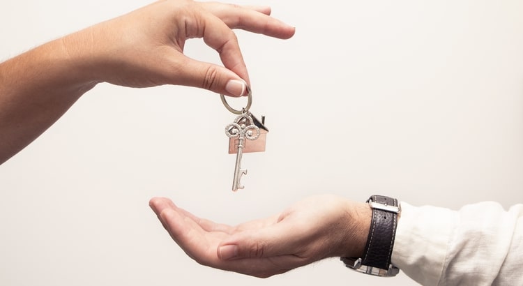 A hand handing a key to another hand