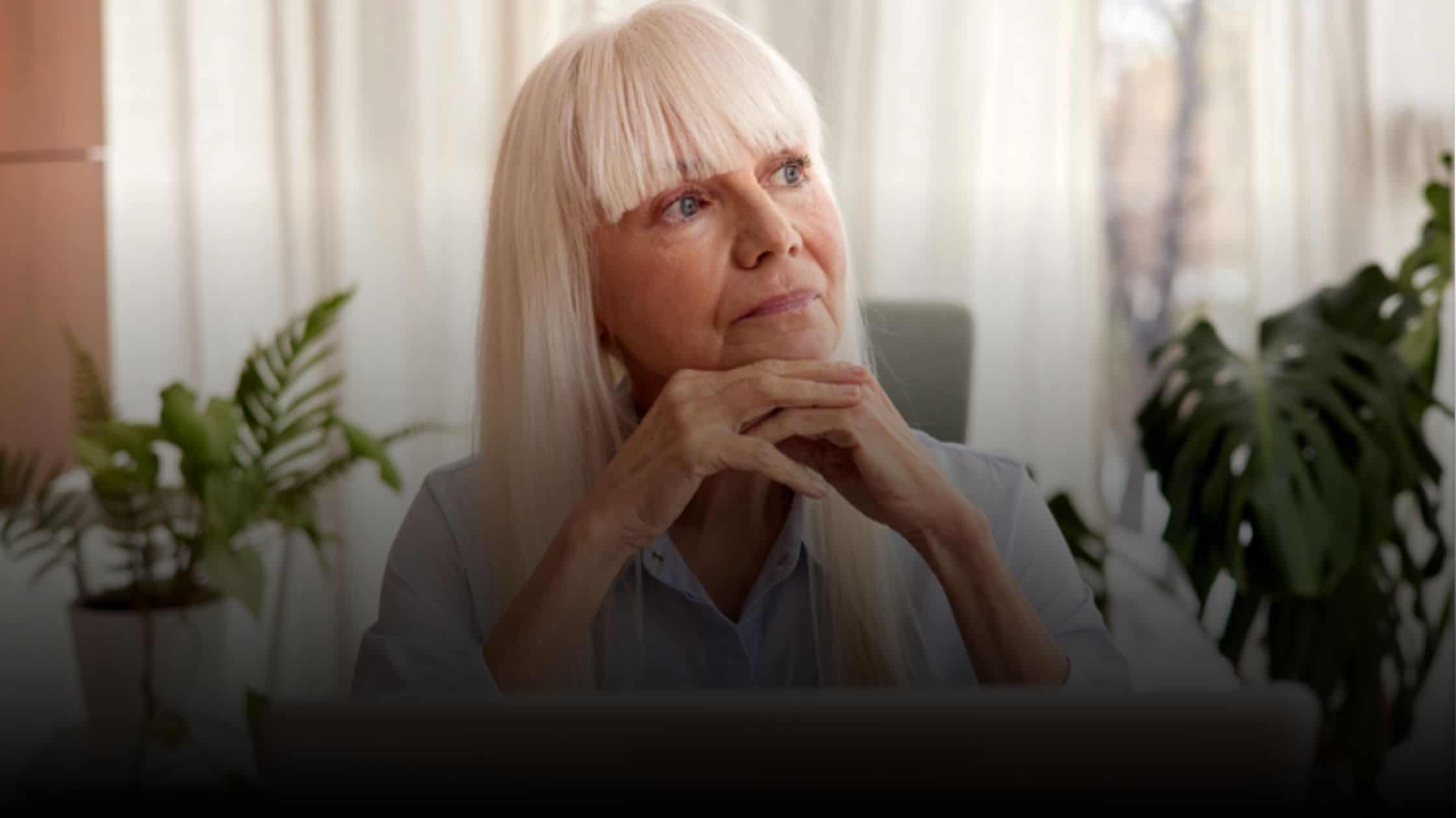 Woman sitting in front of a computer thinking