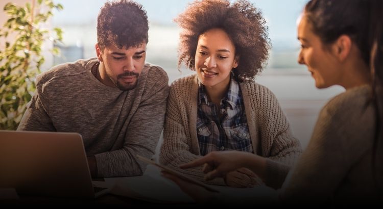 Photo of a woman going over something with a young couple