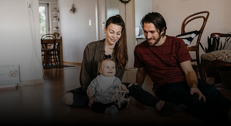 Couple sitting on floor with their toddler