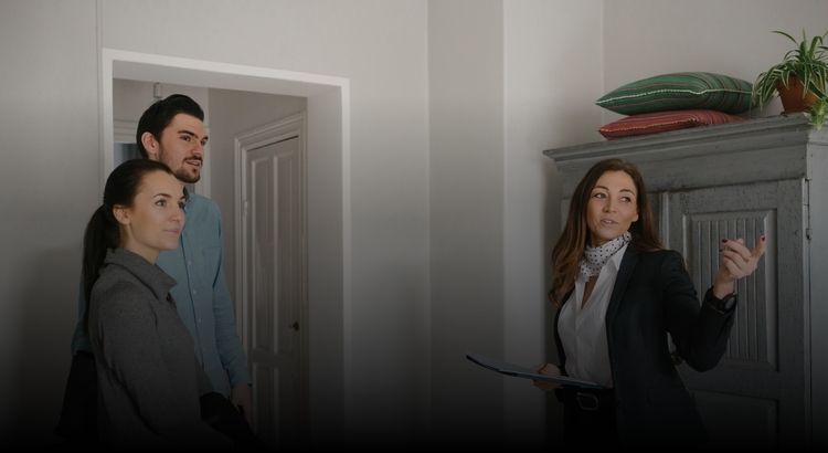 Photo of a real estate agent walking a couple through a home