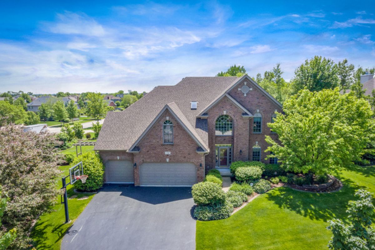 Luxury brick home in the Prairie Trails South neighborhood of Batavia IL with green lawn and mature trees