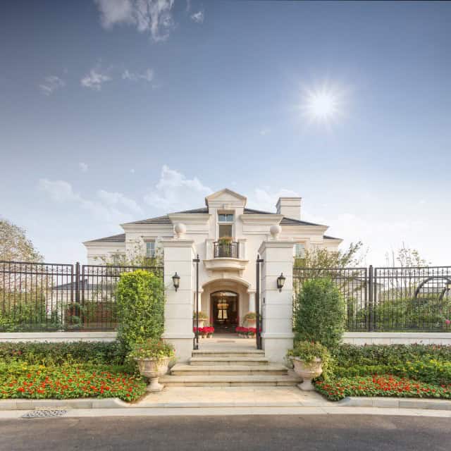 Luxury gated home with bright landscaping