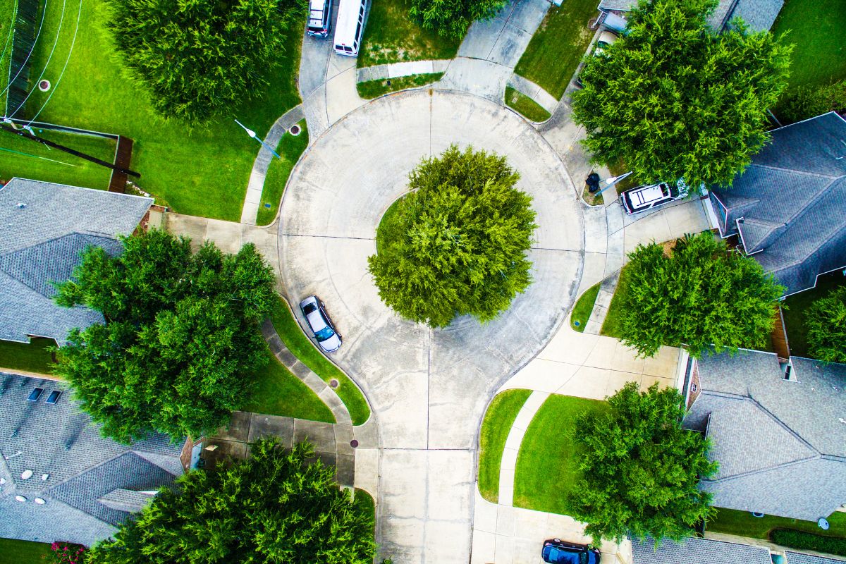 Aerial view of homes surrounding a quiet tree-lined cul-de-sac in a suburban neighborhood