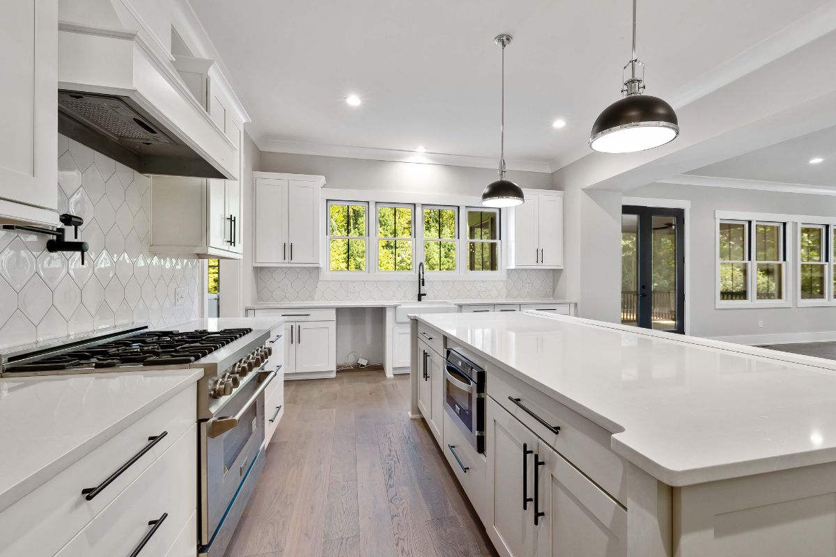 Custom remodeled kitchen with white cabinets, quartz countertops, premium appliances, and a large center island
